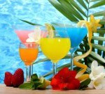 16196011-exotic-cocktails-and-flowers-on-table-on-blue-sea-background