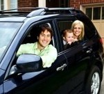 5526048-happy-young-family-sitting-in-black-car-looking-out-windows